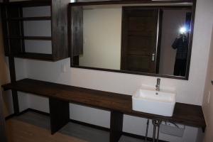 洗面部はカウンターの造作の洗面とし、壁面には大きな鏡と収納棚などを取り付けました